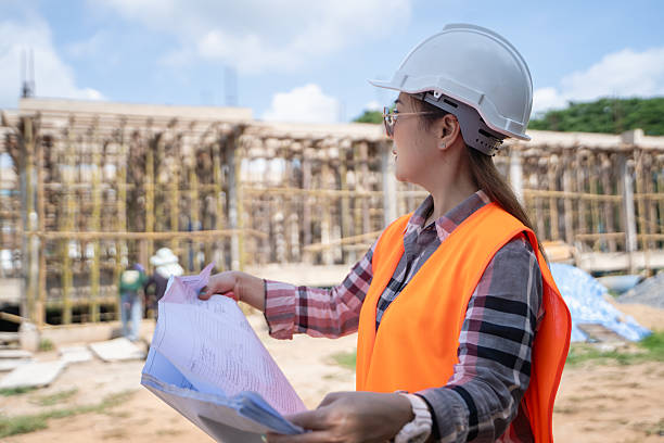 istock Asian female engineer supervising construction work inspecting blueprints at construction site 2223405350