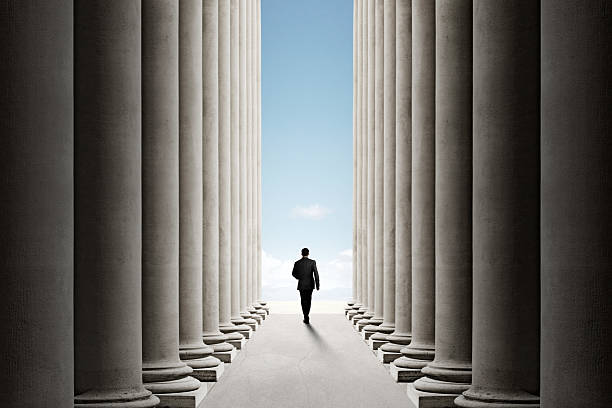 istock Man Walking Through Corridor Of Columns 2223408765