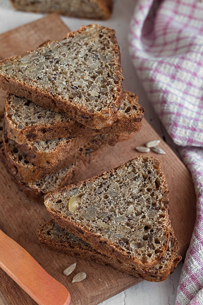 istock Triangular sliced bread with sunflower seeds on a wooden board. Healthy eating concept. 2223409122