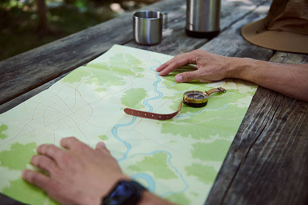 istock Hands Examining a Topographic Map on a Wooden Table Outdoors 2223414570