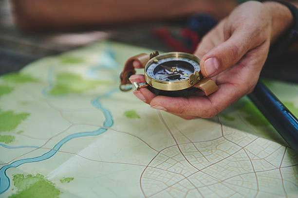 istock Traveler Holding a Compass Over a Map Highlights Navigation and Exploration 2223414591