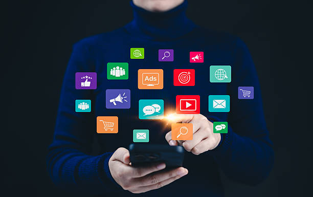 Digital Marketing Strategy and Social Media Network Concept. A woman using a smartphone while colorful icons representing social media, video, ads, messaging, and e-commerce digital marketing tools.
