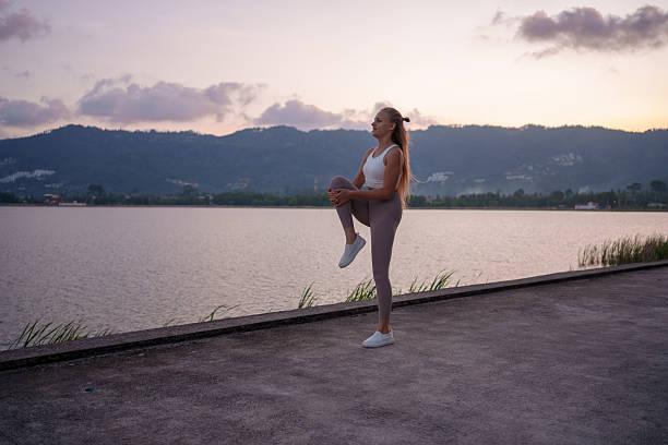 istock Woman Practicing Yoga at Dusk by Serene Lakeside, Promoting Inner Peace 2223420114