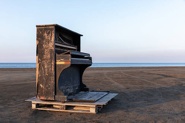 istock Old piano placed on wooden pallets in a serene beach setting 2223421372