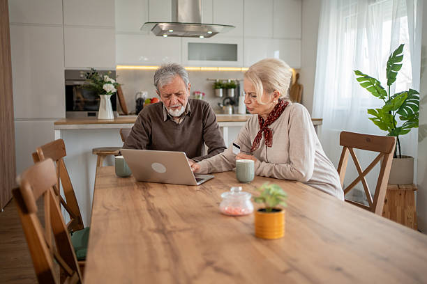 istock Senior couple using laptop in modern kitchen 2223421457