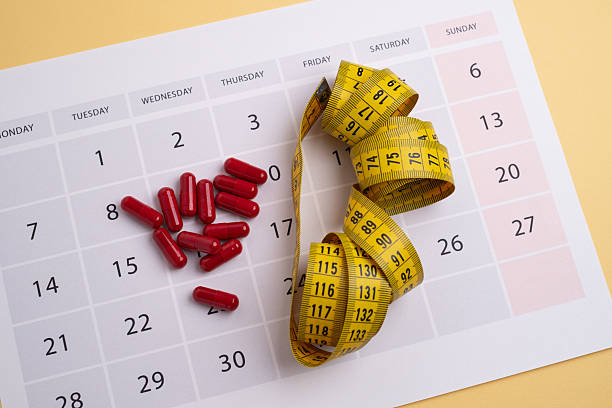 istock Measuring tape and tablets, vitamins on a light background with space for text. Concept of losing weight, dieting, burning fat, healthy eating. 2223421612