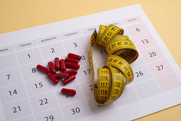 istock Measuring tape and tablets, vitamins on a light background with space for text. Concept of losing weight, dieting, burning fat, healthy eating. 2223421637