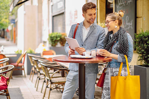 istock Friends are sharing a tablet in a sidewalk cafe 2223424299
