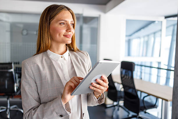 istock Confident businesswoman using tablet in modern office 2223425064