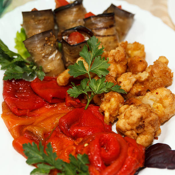 Grilled vegetable medley served on a white plate in Barcelona - Spain, featuring zucchini, eggplant, peppers, and tomato. A colorful, healthy dish with visible grill marks and vibrant culinary presentation.