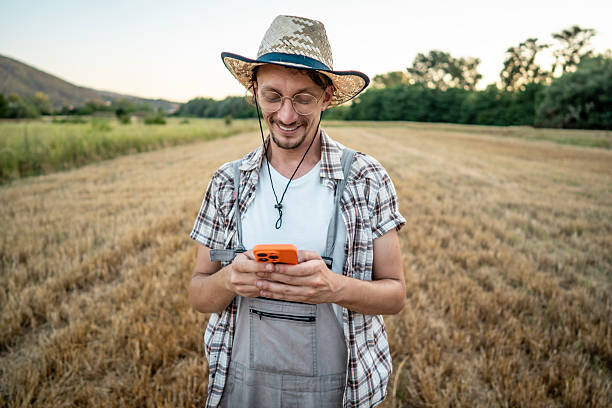 istock Happy Farmer Using Smartphone in a Field on a Sunny Day 2223429056