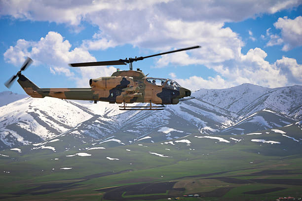 istock Attack helicopter flying over the snowcapped mountains. 2223432605