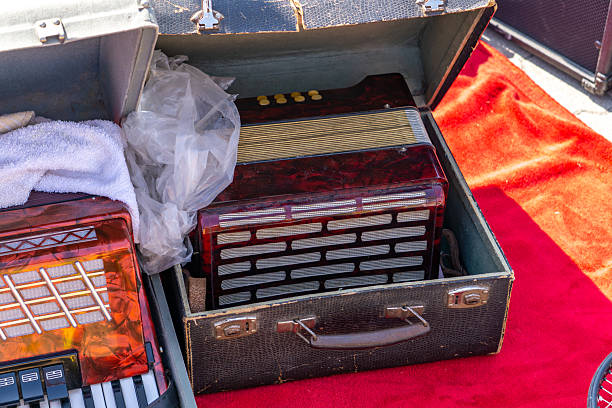Vintage button accordions in open cases at a flea market
