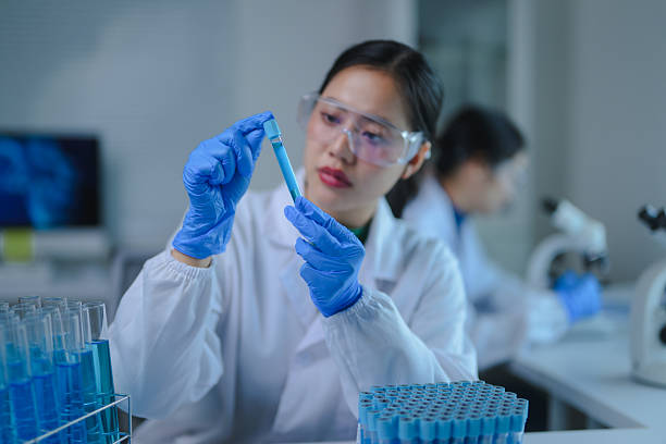 istock Young adult scientist analyzing a blue liquid sample in a laboratory setting with precision 2223439600