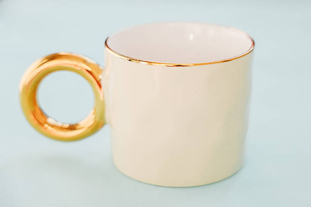 Elegant golden handle cup on a soft background for stylish beverage enjoyment