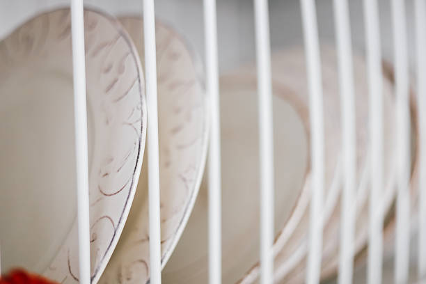 Brightly colored plates are neatly arranged in a dish rack drying after being thoroughly washed. The circular design adds charm to the kitchen.