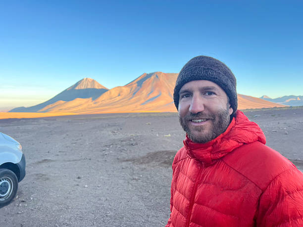 istock Man in Red Jacket Near Desert Volcanoes 2223445011