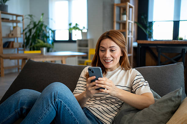 istock Woman relaxing on sofa using smartphone at home 2223451574