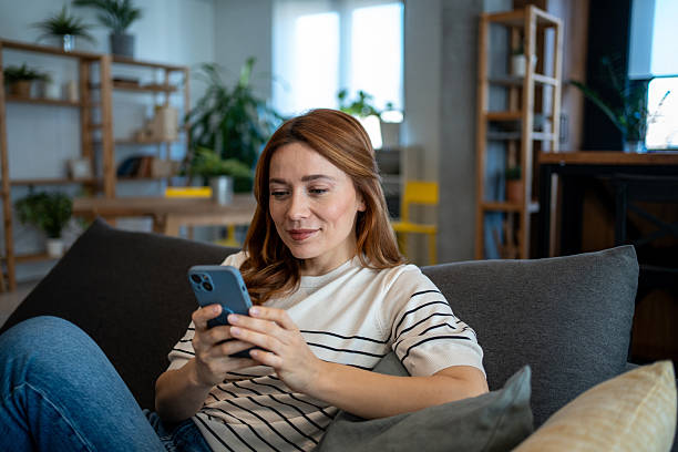 istock Woman relaxing on sofa using smartphone at home 2223451579