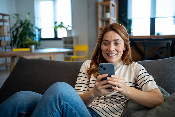 istock Woman relaxing on couch using smartphone 2223451587