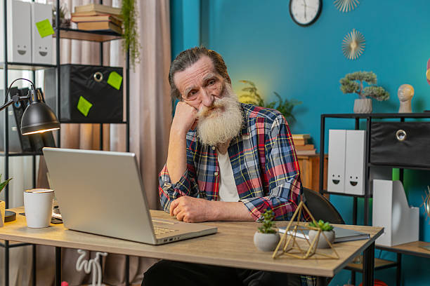 istock Thoughtful senior man looking away thinking solving problem with laptop make decision lack of ideas 2223454239