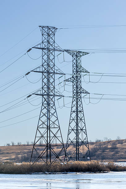 istock Towering Power Lines Over Icy Waters on a Clear Winter Day  Vertical 2223455237