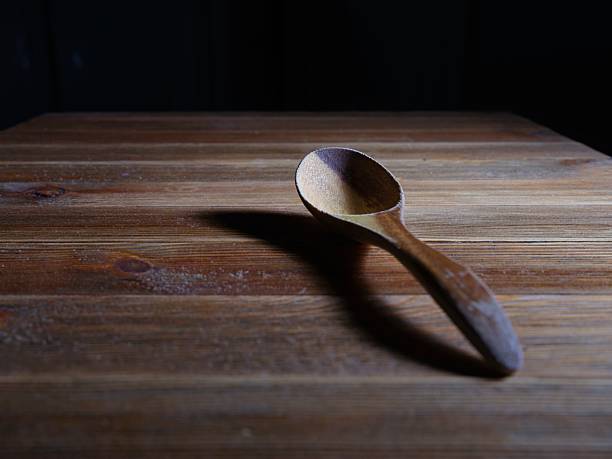 Single wooden spoon isolated on white background. Kitchen utensil for cooking and food preparation.