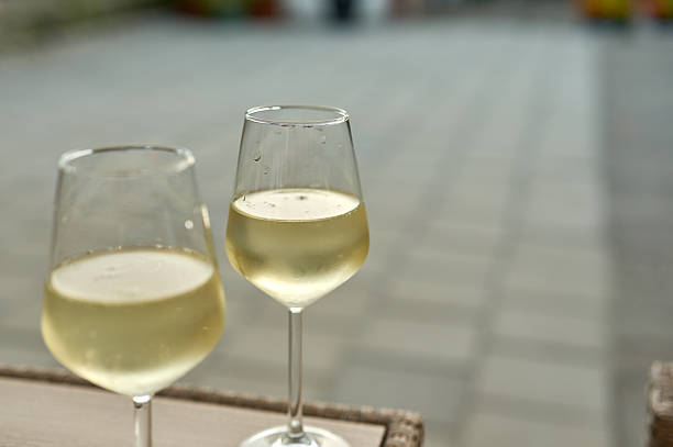 istock Two glasses of cold white wine resting on a table 2223457302