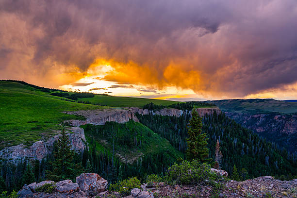 Storm Clouds Over Rugged Canyon Sunset Scenic Landscape - Dramatic storm clouds over mountain canyon from high vantage point. Flat Tops Mountains, Colorado USA.
