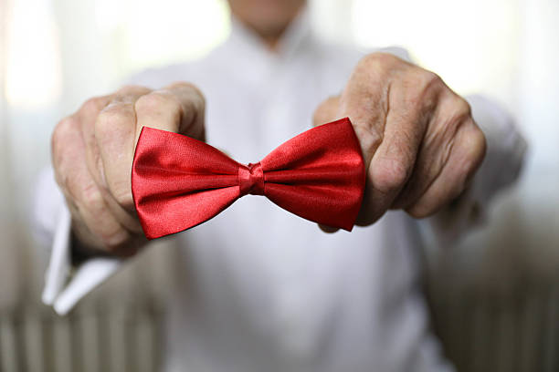 istock Senior Man Holding a Red Bow Tie 2223458401