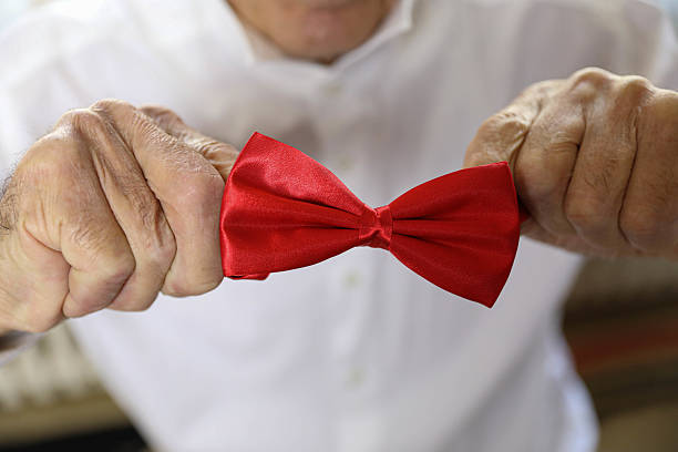 istock Senior Man Holding a Red Bow Tie 2223458403