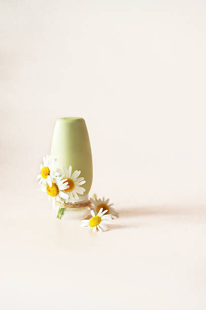 istock Cosmetic bottle on light background decorated with fresh chamomile flowers 2223458645