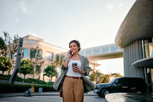 istock Businesswoman walking and talking on phone while holding coffee 2223459148