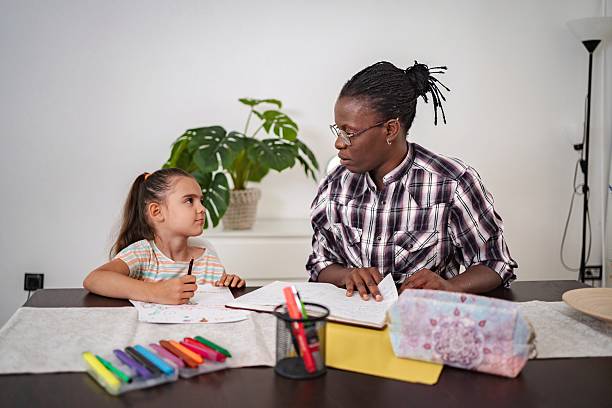 istock Tutor helping young girl with her homework 2223461217