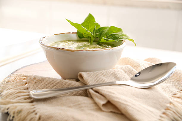 A comforting bowl of hot soup served with a spoon, ideal for cozy meals on cold days. The steam rising and rustic presentation evoke warmth, nourishment, and homemade goodness.