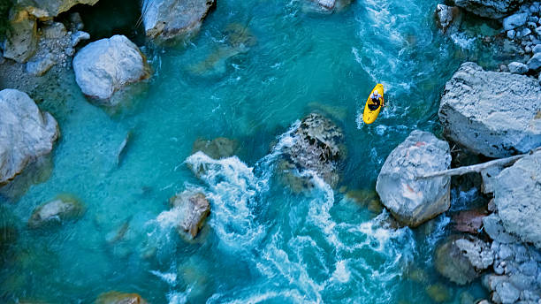 istock Kayaker conquers rapids, navigating through a rocky river 2223465789