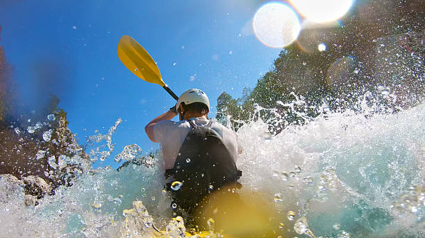 istock Kayaker conquers rapids, splashing water and sunlight glare 2223465799