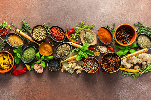 istock A stunning spread of fresh spices and herbs, meticulously arranged on a deep brown backdrop, capturing their vibrant colors and tantalizing aromas 2223470588