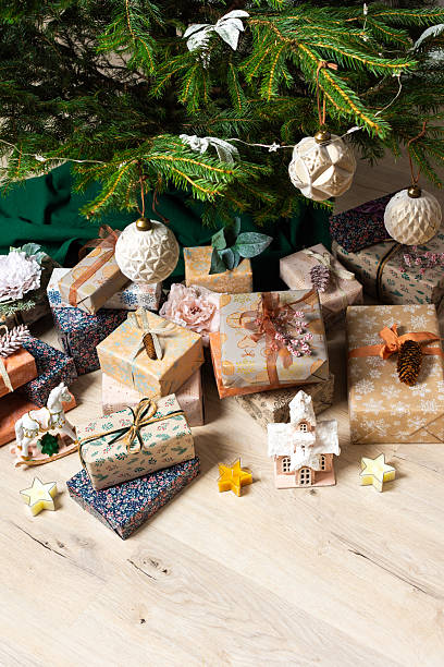 istock A cozy Christmas scene with elegant natural-toned gift boxes placed under a Christmas tree, lit with festive lights, evoking peace and seasonal joy 2223470591