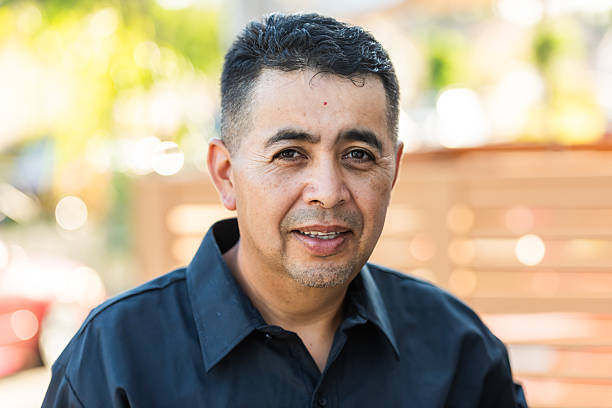 istock Headshot of a smiling mature Hispanic man posing looking at camera 2223470940