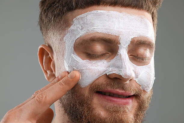 istock Handsome man with facial mask on his face against grey background 2223482242