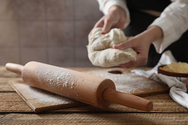 istock Woman making dough at wooden table, selective focus 2223482464