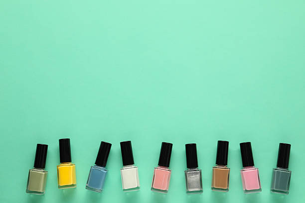 istock Bright nail polishes in bottles on turquoise background, flat lay. Space for text 2223483967