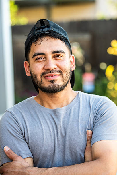 Headshot of a  smiling young  Hispanic man posing looking at camera