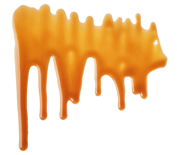 istock Dripping abstract Melted caramel sauce drops on white background 2223486533