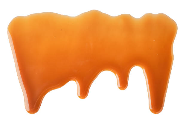 istock Dripping Melted caramel sauce abstract drops on white background 2223486535