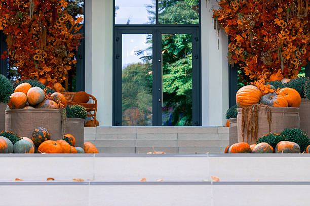 hotel beige panel facade building entrance orange foliage and pumpkin decorative elements October and Halloween aesthetic
