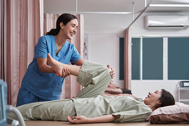 istock Hispanic female physical therapist stretches patient's legs on massaging bed. 2223494965