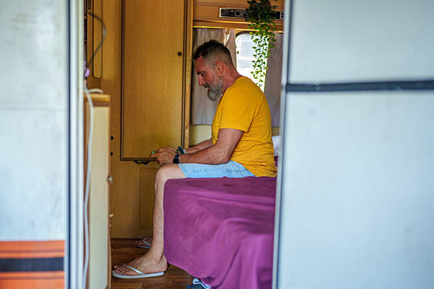 istock Mature man playing videogames with smartphone inside his caravan 2223497519