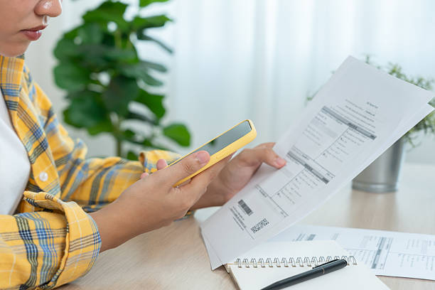 istock woman use phone scan barcode or QR codes to pay credit card bill after receiving document invoice. payment, receive, paying electricity, digital payments, technology, scanning, financial transactions 2223501381